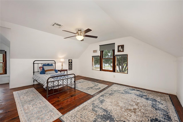 bedroom with dark wood-style floors, baseboards, visible vents, and vaulted ceiling