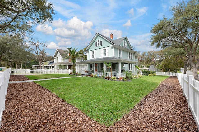 view of front of property with a porch, a chimney, a front yard, and fence private yard