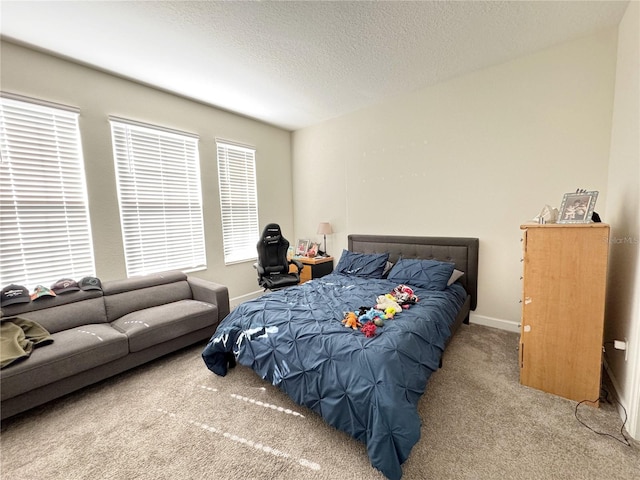 bedroom with carpet floors, baseboards, and a textured ceiling