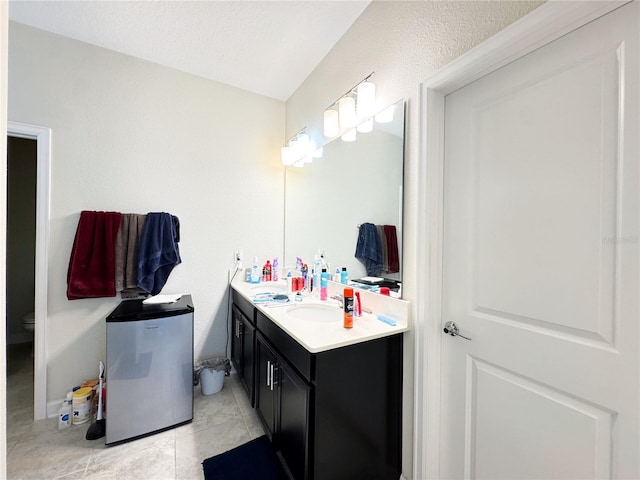 bathroom with tile patterned flooring, a sink, toilet, and double vanity