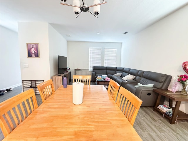 dining area with baseboards, visible vents, and wood finished floors