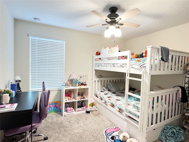 bedroom with a textured ceiling, carpet floors, and ceiling fan