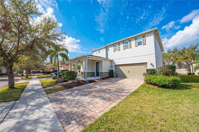 view of front of property with a garage, stucco siding, decorative driveway, and a front yard