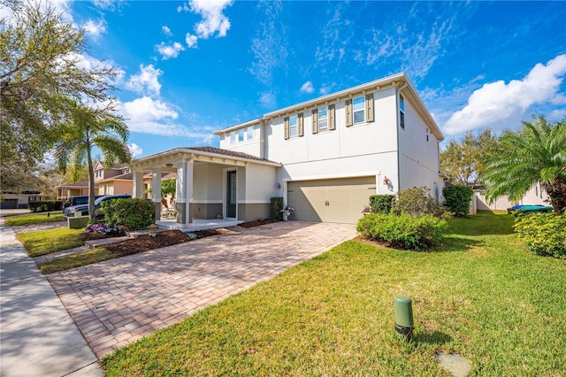 view of front of home featuring a garage, a front lawn, decorative driveway, and stucco siding