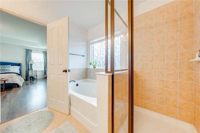 bathroom featuring a garden tub, a shower stall, ensuite bath, and tile patterned floors