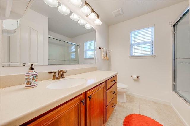 full bathroom featuring toilet, plenty of natural light, vanity, and tile patterned floors