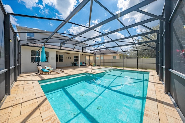 view of swimming pool with glass enclosure, fence, a fenced in pool, and a patio