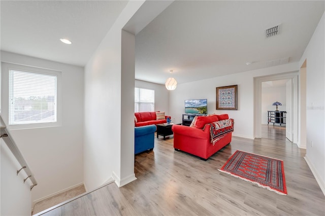 living room featuring baseboards, visible vents, and wood finished floors