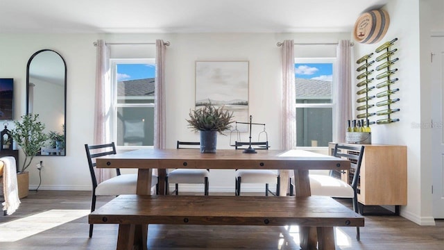 dining space featuring dark wood-style floors, plenty of natural light, and baseboards