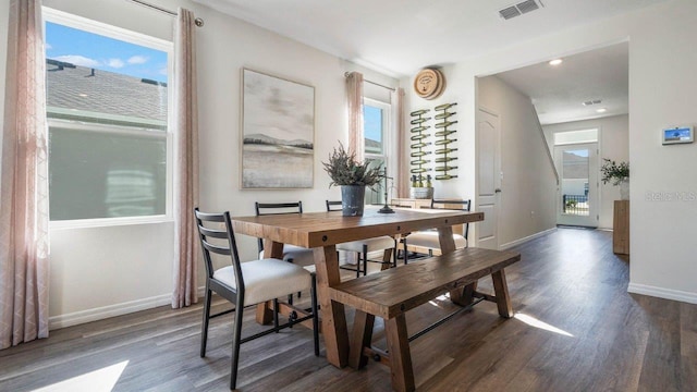 dining area featuring dark wood-style flooring, plenty of natural light, visible vents, and baseboards