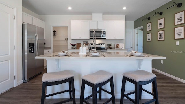 kitchen featuring an island with sink, white cabinetry, and stainless steel appliances