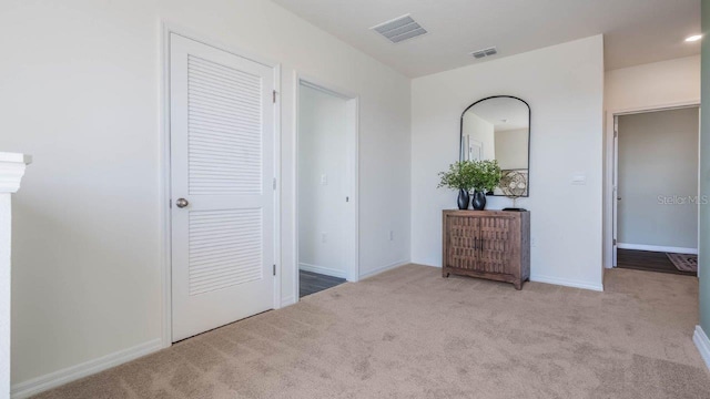 unfurnished bedroom featuring light colored carpet, visible vents, and baseboards