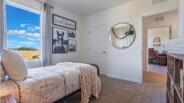 carpeted bedroom with visible vents and baseboards