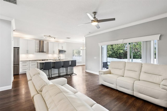 living room featuring dark wood-style floors, visible vents, crown molding, and baseboards