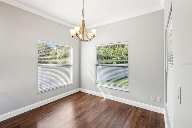 spare room with baseboards, dark wood finished floors, a notable chandelier, and ornamental molding