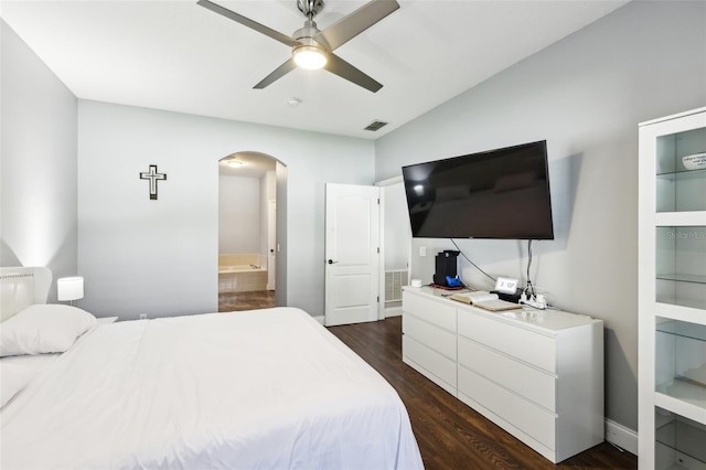 bedroom featuring arched walkways, ceiling fan, dark wood-style flooring, visible vents, and ensuite bath