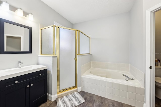 full bathroom featuring a garden tub, toilet, a stall shower, vanity, and wood finished floors