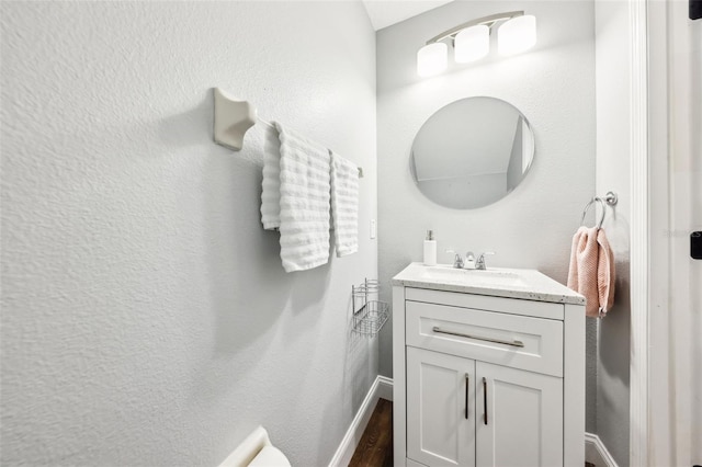 bathroom with vanity, baseboards, and wood finished floors