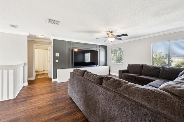 living room with dark wood-style flooring, visible vents, crown molding, and a textured ceiling