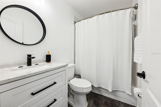 bathroom with toilet, vanity, wood finished floors, shower / bath combination with curtain, and a textured ceiling