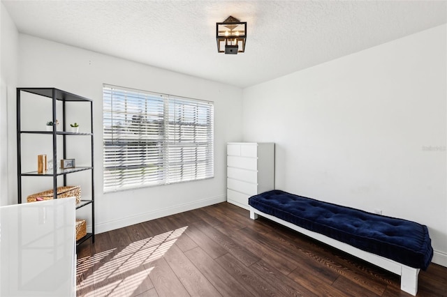 bedroom with dark wood-style floors, baseboards, and a textured ceiling