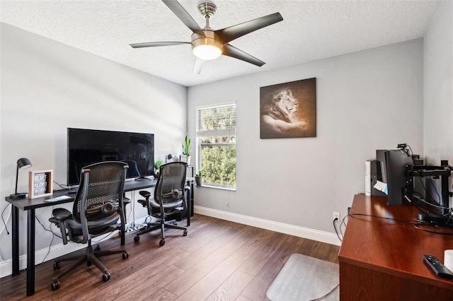 office area featuring dark wood-style floors, a textured ceiling, baseboards, and a ceiling fan