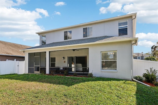 rear view of property with stucco siding, a lawn, a ceiling fan, a sunroom, and a fenced backyard