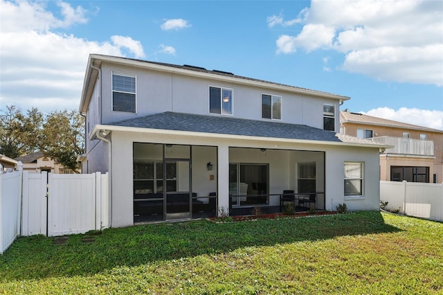 back of property featuring a yard, fence, and stucco siding