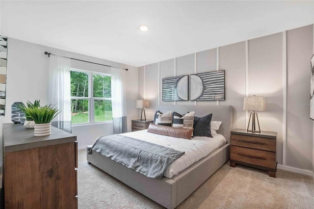 bedroom with baseboards and light colored carpet