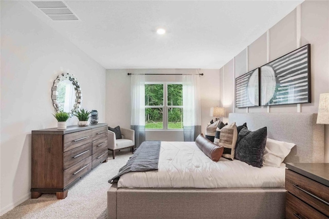 bedroom featuring visible vents, light carpet, and baseboards