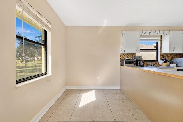 kitchen featuring light countertops, backsplash, and white cabinets