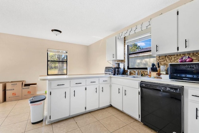 kitchen with a sink, white cabinetry, a healthy amount of sunlight, light countertops, and dishwasher