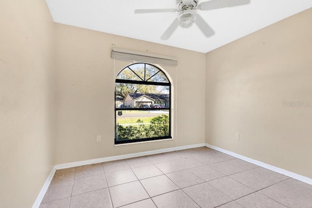 unfurnished room featuring a ceiling fan, light tile patterned flooring, and baseboards