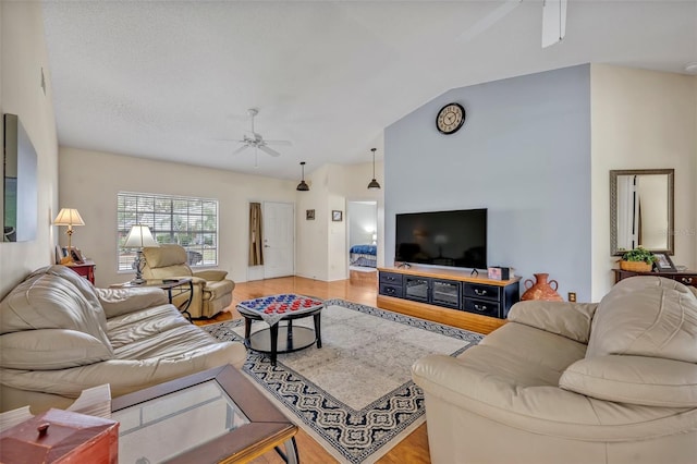 living room featuring a ceiling fan, lofted ceiling, and light wood-type flooring