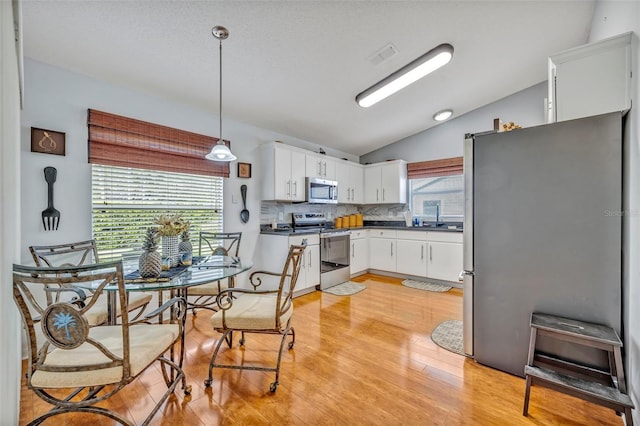 kitchen with plenty of natural light, stainless steel appliances, tasteful backsplash, and dark countertops