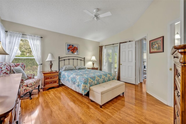 bedroom with light wood-type flooring, access to exterior, multiple windows, and vaulted ceiling