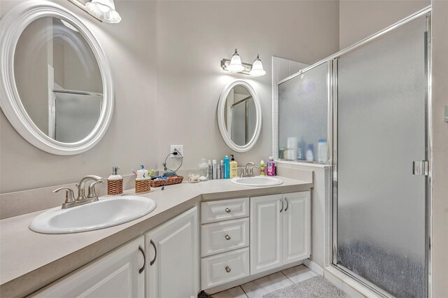 bathroom with a stall shower, a sink, and tile patterned floors