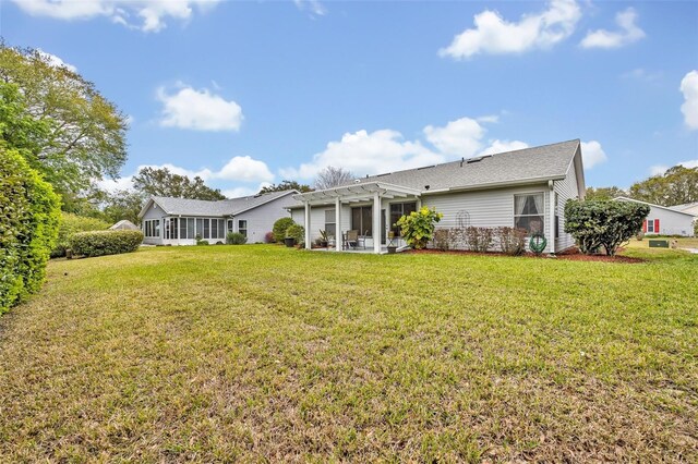 rear view of house with a lawn and a pergola