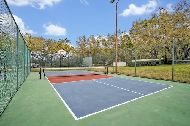 view of tennis court featuring community basketball court and fence