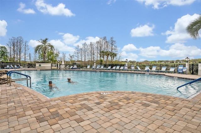 pool featuring fence and a patio