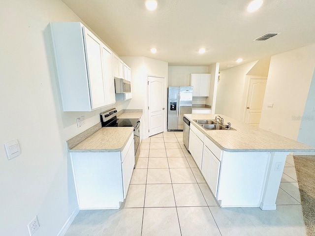 kitchen featuring white cabinets, an island with sink, stainless steel appliances, light countertops, and a sink