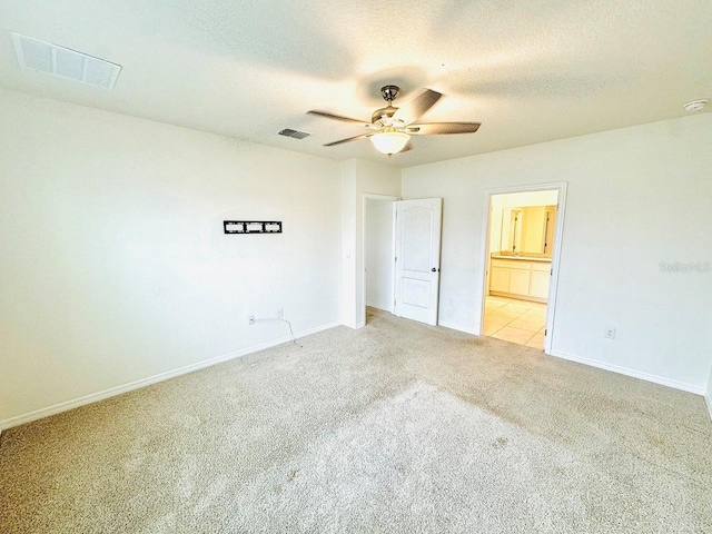 unfurnished bedroom with visible vents, light carpet, and a textured ceiling