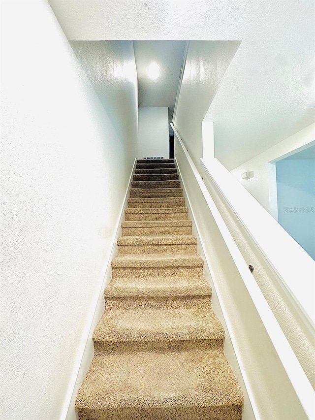 stairway with a textured ceiling