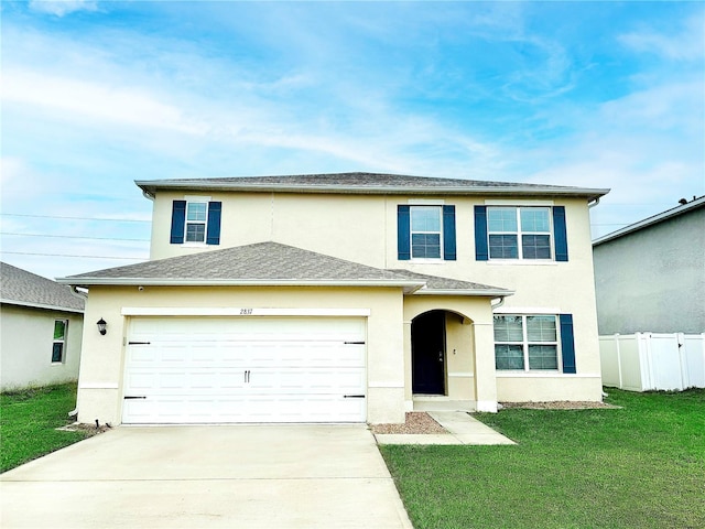 traditional-style home featuring a front yard, driveway, an attached garage, and stucco siding