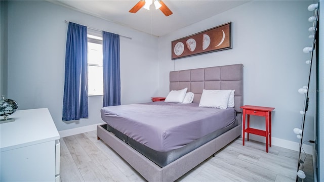 bedroom with light wood-style floors, baseboards, and a ceiling fan