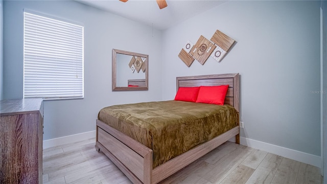 bedroom featuring baseboards, ceiling fan, and light wood finished floors