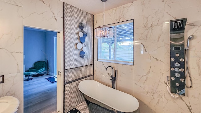 bathroom featuring a freestanding tub and wood finished floors