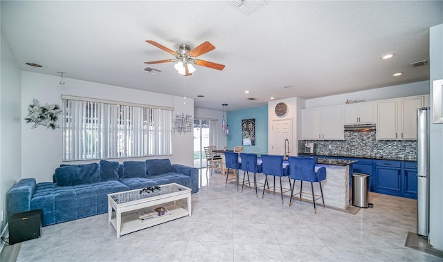 living room with visible vents, a ceiling fan, and recessed lighting