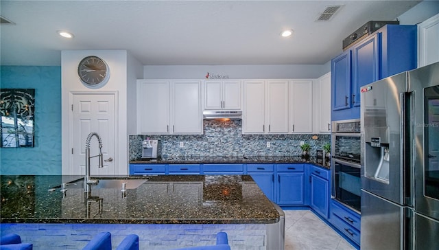 kitchen featuring white cabinets, under cabinet range hood, blue cabinets, and stainless steel appliances