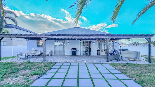 back of property with a patio, stucco siding, a hot tub, an outdoor hangout area, and fence private yard